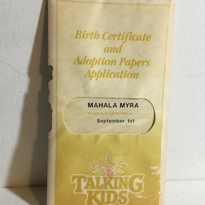 May include: A vintage birth certificate and adoption papers application. The document is in a yellowed envelope with the text "Birth Certificate and Adoption Papers Application." The name "Mahala Myra" and the date "September 1st" are visible.
