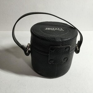 May include: A black leather camera case with a silver metal clasp and the word "Vivitar" embossed on the top.