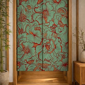May include: A rectangular fabric noren curtain featuring a repeating floral pattern with light green petals and bold red outlines. The curtain is split down the centre and hangs within a wooden door frame, displaying large, stylised flower blossoms.