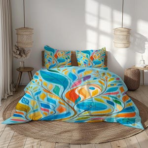 Peut inclure: Une housse de couette bleu clair et deux taies d'oreiller avec un motif floral coloré. Le motif présente de grandes feuilles et des formes abstraites dans des tons de bleu, orange, jaune et rose. La literie est sur un lit avec une tête de lit en bois.