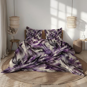 May include: Purple and black abstract patterned bedding with a white background. The bedding is on a bed with two pillows and a brown rug.