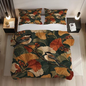 May include: A bedding set featuring a duvet cover and two pillowcases with a dark green background, patterned with orange and cream ginkgo leaves, red berries, and small birds perched on branches. The set is displayed on a white bed frame.