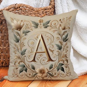 Elegante funda de almohada con monograma y detalles en beige, dorado, verde y marrón. Funda de almohada de lino y algodón. Impresión a doble cara. Varios tamaños.