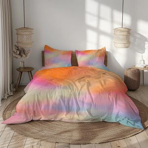 Op de afbeelding: Een tie-dye beddengoedset in tinten oranje, roze, geel en blauw. De set bevat een dekbedovertrek en twee kussenslopen. Het beddengoed wordt getoond op een bed met een houten hoofdbord en een rond, geweven vloerkleed.