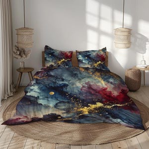 Può includere: Un copripiumino con un design astratto ad acquerello blu, rosso e oro. Il copripiumino presenta un motivo a spirale di colori e accenti dorati.