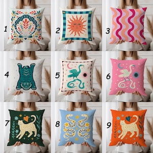 Könnte beinhalten: Neun dekorative Zierkissen mit verschiedenen Designs. Kissen zeigen eine Muschel, Sonne, Wellenlinien, Tiger, Vogel mit Schlange, Leopard und Schlangen. Farben sind Teal, Orange, Pink und Gelb. Die Kissen sind quadratisch und aus Stoff.