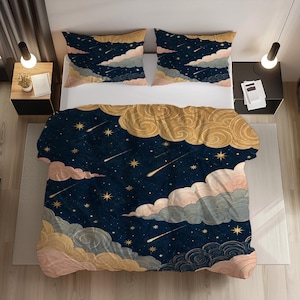 May include: A bedding set featuring a dark navy blue background with a celestial pattern of gold stars, shooting stars, and swirling clouds in shades of pale pink, muted blue, and golden yellow. The set includes a duvet cover and two pillowcases.