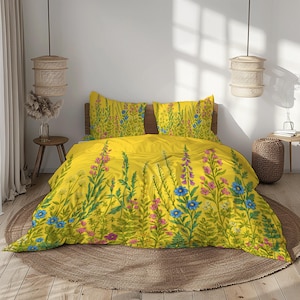 Può includere: Set di biancheria da letto floreale giallo con copripiumino e due federe. Il design include steli e foglie verdi con fiori rosa e blu. La biancheria da letto è posizionata su un tappeto rotondo intrecciato.