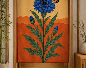 Puede incluir: Una cortina de puerta rectangular de tela que presenta una ilustración central de un gran aciano azul con hojas verdes y dos capullos más pequeños. Una mariposa monarca naranja y negra descansa sobre la flor. El fondo es un degradado de amarillo y naranja.