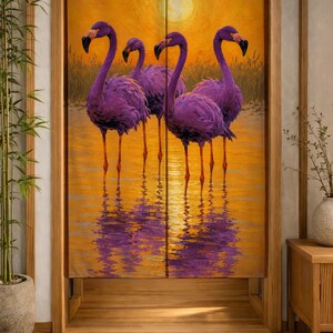 Könnte beinhalten: Ein rechteckiger Türvorhang aus Stoff mit einem lebendigen Ölgemälde-Druck von vier violetten Flamingos, die in flachem Wasser stehen. Der Hintergrund zeigt einen leuchtend orangefarbenen Sonnenuntergang mit einer großen gelben Sonne.