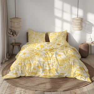 May include: A bed with a white and yellow floral patterned duvet cover and pillowcases. The bedding set is on a round, woven rug. The room has a natural, bohemian aesthetic with woven pendant lights.