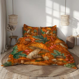 Può includere: Un set di biancheria da letto composto da un copripiumino e due federe con una stampa a tema autunnale. Il motivo presenta vari funghi, ghiande marroni e foglie d'acero verdi su uno sfondo arancione brillante con bacche rosse.