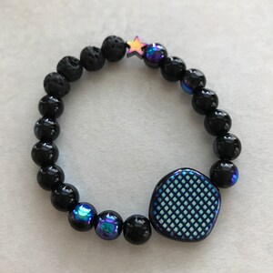 Peut inclure: Bracelet en perles noires avec un charme à motif bleu et blanc, un charme étoile noire et des perles bleues irisées.