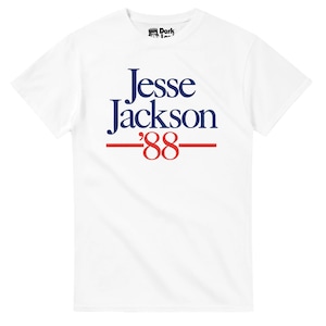 May include: White t-shirt featuring the name "Jesse Jackson" in navy blue, with "'88" in red, and a red line underneath. The shirt has a crew neck and short sleeves. The Dark Icon logo is visible on the upper left.