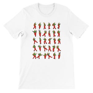 May include: White t-shirt featuring a repeating pattern of a person in a red outfit with a green shirt and white hat in various poses. The graphic is a cartoon-style illustration.