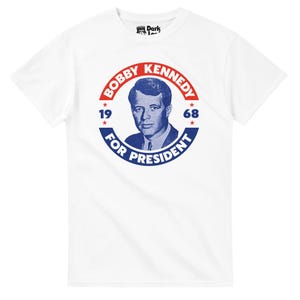 May include: White t-shirt featuring a blue and red graphic of Bobby Kennedy with the text "Bobby Kennedy For President 1968". The design is a vintage style, with a portrait of Kennedy in the center.