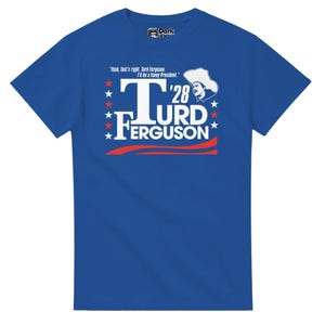 May include: A royal blue t-shirt with a white graphic of a man wearing a cowboy hat and the text "Turd Ferguson '28" with red stars and a red and white wave design.