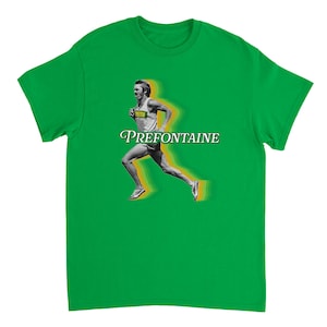 May include: Green t-shirt with a graphic of a runner and the name "PREFONTAINE". The runner is shown in motion with a yellow and green motion blur effect, wearing a white vest and shorts. The text is in a stylized font.