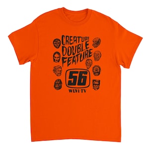 May include: Orange t-shirt with a black graphic design. The design features the text "CREATURE DOUBLE FEATURE" above the number "56" inside a rectangle, surrounded by various monster faces. The text "WLVI-TV" is below the number.