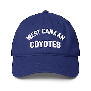 Op de afbeelding: Een koningsblauwe baseballcap met de witte tekst "WEST CANAAN COYOTES". De cap heeft een gebogen klep en een stoffen bandsluiting aan de achterkant. Ideaal voor sportliefhebbers.