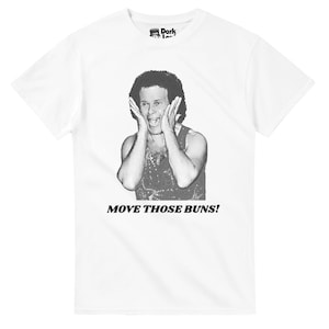 Puede incluir: Camiseta blanca con una imagen en blanco y negro de una persona con las manos en la cara y el texto "MOVE THOSE BUNS!". La camiseta tiene cuello redondo y mangas cortas. El logotipo de la marca es visible en la parte superior.