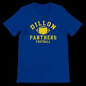 Puede incluir: Camiseta azul real con un gráfico amarillo desgastado. El gráfico incluye la palabra "DILLON" encima de un balón de fútbol y las palabras "PANTHERS FOOTBALL" debajo. La camiseta es de cuello redondo y tiene mangas cortas.