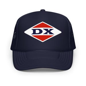 Könnte beinhalten: Marineblaue Trucker-Mütze mit einem weiß, rot und blau diamantförmigen Logo mit der Aufschrift "DX". Die Mütze hat eine Mesh-Rückseite und einen gebogenen Schirm. Ein klassisches Accessoire.