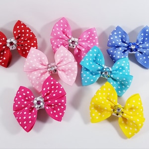 May include: A set of ten mini polka dot hair bows with a rhinestone center. The bows are in various colors, including red, pink, blue, yellow, and turquoise.