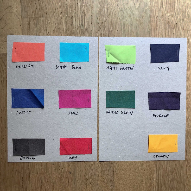 K&ouml;nnte beinhalten: Eine Farbkarte mit Stoffmustern in verschiedenen Farben, darunter Orange, Hellblau, Hellgr&uuml;n, Marineblau, Kobalt, Pink, Dunkelgr&uuml;n, Lila, Braun, Rot und Gelb. Die Farben sind unter jedem Muster beschriftet.