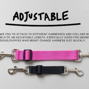 May include: Adjustable dog leash with two silver clips and a pink strap. The leash is adjustable to fit different harnesses and collars. "ADJUSTABLE" is written in black marker at the top of the image.