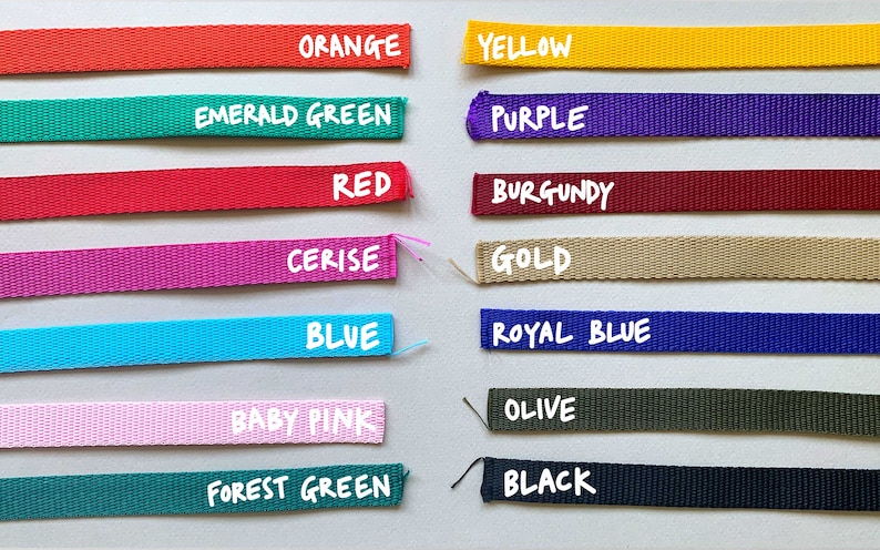May include: A collection of 14 different colored webbing straps with the color name written in white text below each strap. The colors are orange, yellow, emerald green, purple, red, burgundy, cerise, gold, blue, royal blue, baby pink, olive, forest green, and black.
