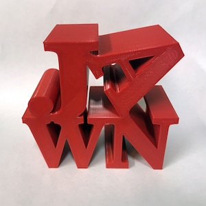 May include: Red 3D printed letters spelling out "J.K. WIN" stacked on top of each other.