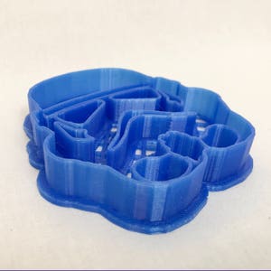 May include: A blue plastic cookie cutter shaped like a Star Wars Stormtrooper helmet.