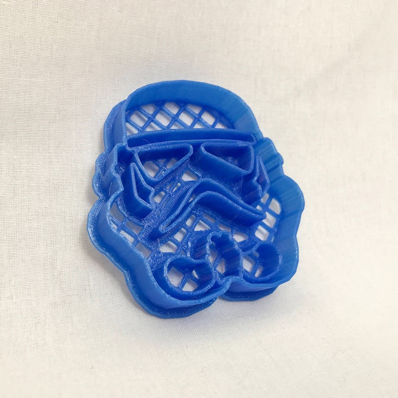 May include: A blue plastic cookie cutter shaped like a Star Wars Stormtrooper helmet.