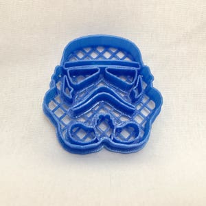 May include: A blue plastic cookie cutter shaped like a Star Wars Stormtrooper helmet.