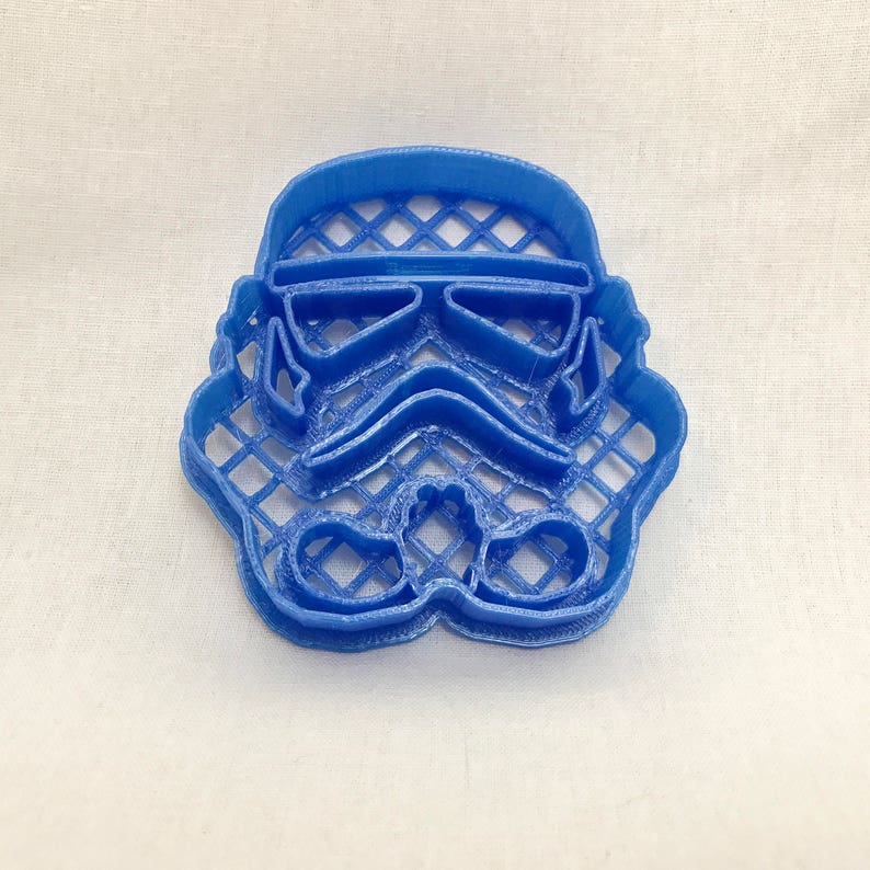 May include: A blue plastic cookie cutter shaped like a Star Wars Stormtrooper helmet.