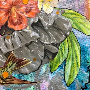 Puede incluir: Un collage de t&eacute;cnica mixta con una flor gris, hojas verdes, una mariposa y un colibr&iacute;. El collage est&aacute; decorado con detalles de purpurina dorada.