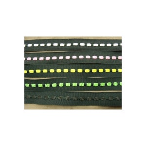 Puede incluir: Cinco diferentes cintas negras con costuras de colores. Las cintas tienen costuras blancas, rosas, amarillas, verdes y negras.