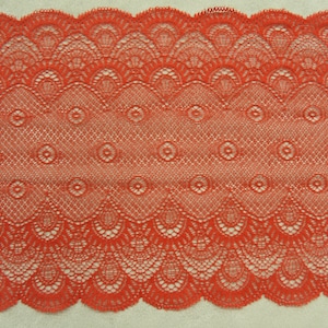 以下が含まれることがあります： 繊細な花柄の赤いレーストリムで、縁は波打っています。