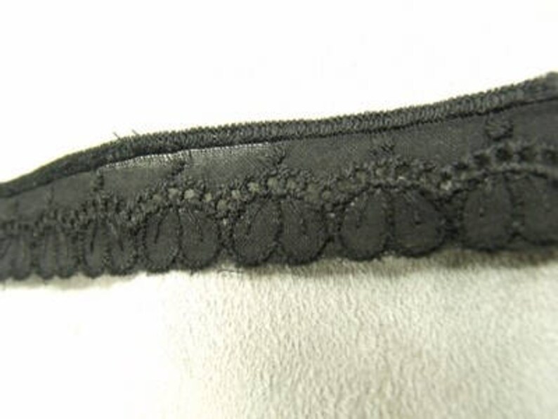 May include: Black lace trim with a scalloped edge.