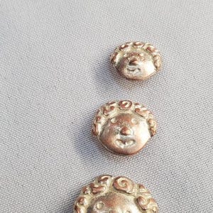 Op de afbeelding: Een set van drie keramische nestkommen in oplopende maten. De kommen zijn wit met een gespikkelde, getextureerde afwerking. De grootste kom heeft een diameter van ongeveer 18 cm.