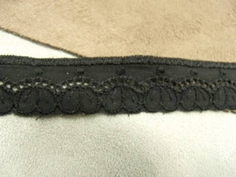May include: Black lace trim with scalloped edges and a solid black band.