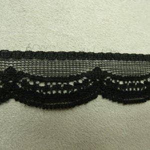 Peut inclure: Garniture en dentelle noire avec un bord festonné. La dentelle est délicate et présente un motif de maille fine.