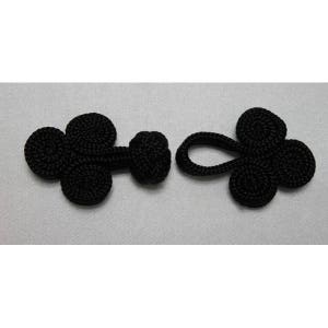 Peut inclure: Deux fermetures à nœuds chinois en tissu noir. Chaque fermeture a trois boucles et un centre noué. Une fermeture a une boucle pour l'attacher à un vêtement.