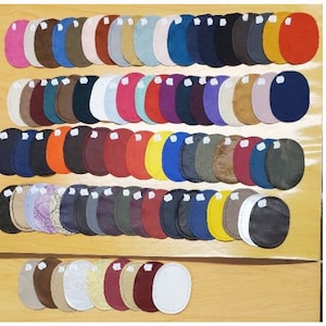 Peut inclure: Assortiment de 70 patchs en cuir de différentes couleurs et textures. Les patchs sont disposés en rangées et en colonnes, chaque patch mesurant environ 5 cm de diamètre.