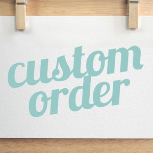 May include: A white card with the text "custom order" in light blue lettering.