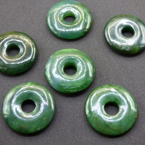 Pu&ograve; includere: Sei perline di giada verde a forma di ciambella con una finitura liscia e lucida. Ogni perlina ha un foro al centro per l'infilaggio.