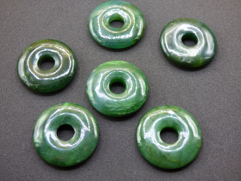 Pu&ograve; includere: Sei perline di giada verde a forma di ciambella con una finitura liscia e lucida. Ogni perlina ha un foro al centro per l'infilaggio.