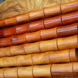 Può includere: Cinque mattarelli in legno con un design segmentato, che vanno dal marrone chiaro al marrone rossiccio.