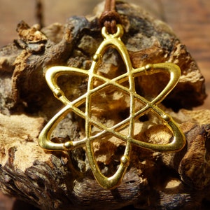 May include: A gold-toned atom pendant necklace with a brown leather cord. The pendant is a stylized representation of an atom with a central nucleus and orbiting electrons.